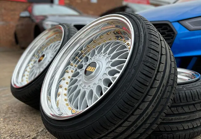 Fully refurbished set of split rim wheels in front of Rolling Rims workshop