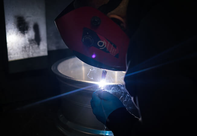 Close up of a cracked alloy wheel being welded by a Rolling Rims employee